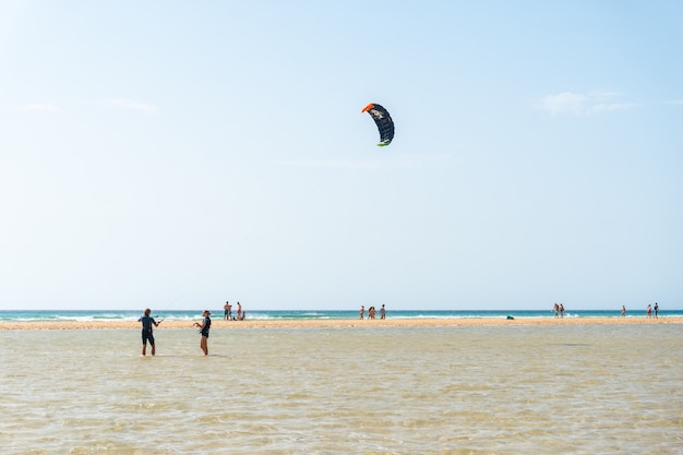 Children learning Kitesurfing or sky surfing on Sotavento beach in the south of Fuerteventura, Canary Islands. Spain