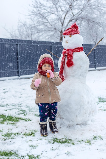 Children make a snowman in winter Selective focus