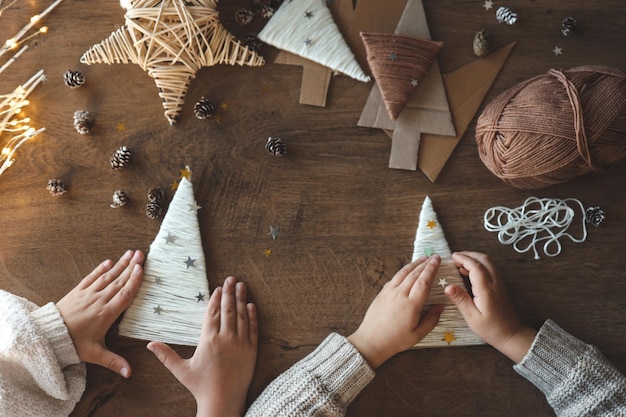 Photo children making christmas decorations from yarn