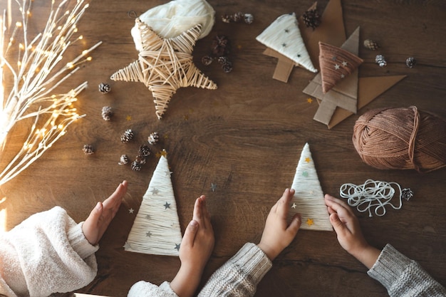 Photo children making christmas decorations from yarn