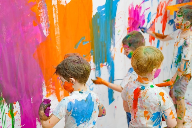 Children paint on the wall and have fun high quality photo