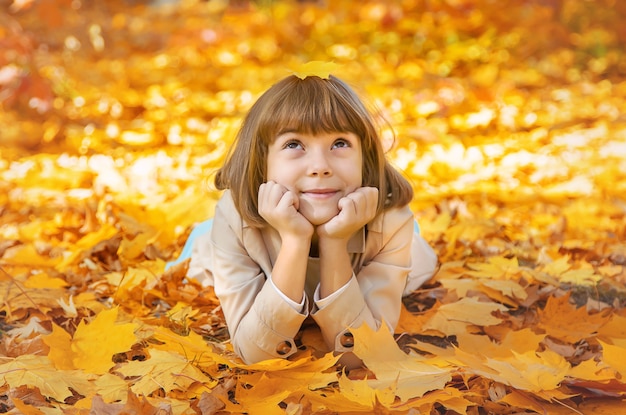 Children in the park with autumn leaves. Selective focus.