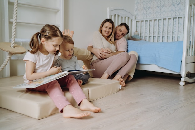 children play in child room Father made a toy pyramide girl reading a book