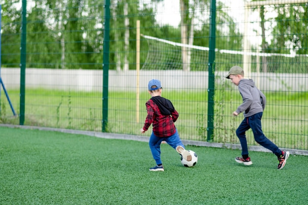 Children play football in the yard on the lawn