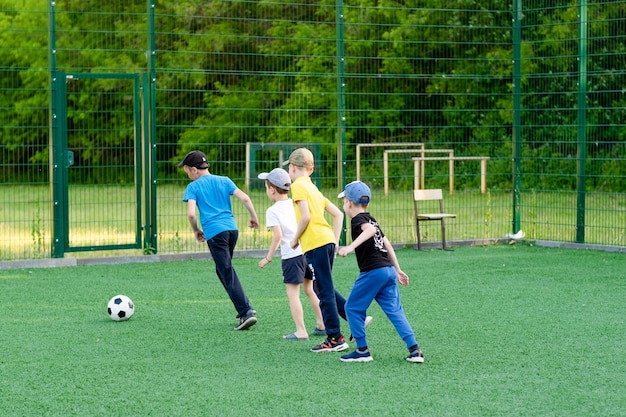 Children play football in the yard on the lawn