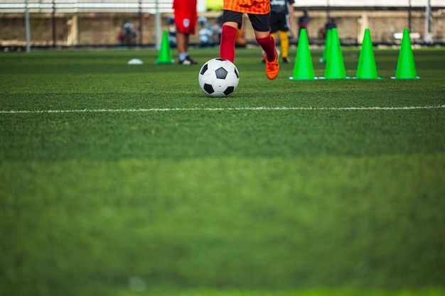 Children playing control soccer ball tactics on grass field with for training