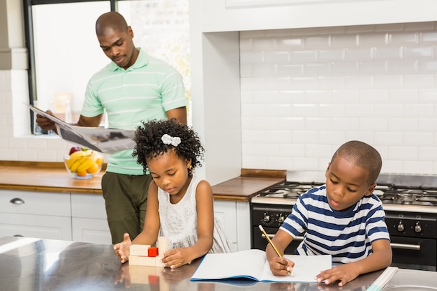 Children playing and drawing in the kitchen