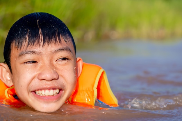 Children playing and swimming in river of organic farm in rural