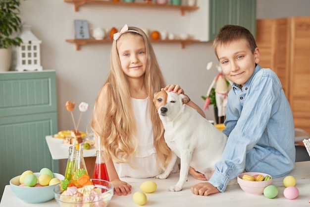 Children playing with their dog on a Easter-decorated table