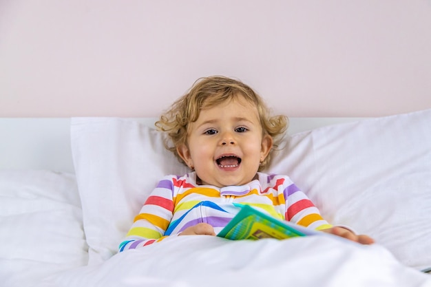 Children read a book in bed Selective focus