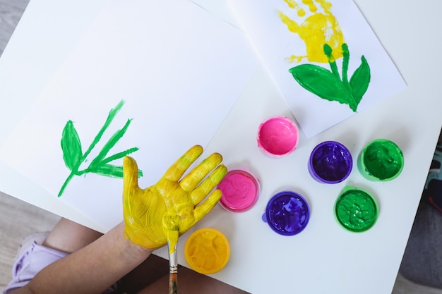 Children's art workshop the child makes a handprint with paints