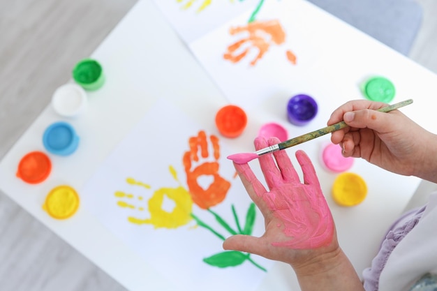 Children's art workshop the child makes a handprint with paints