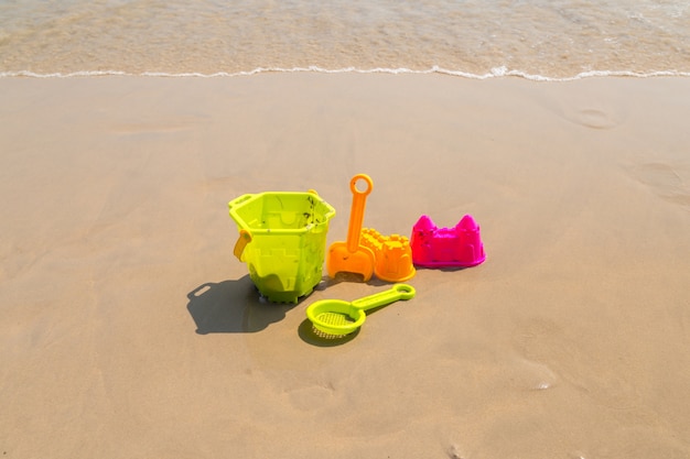 Children's beach toys - buckets, spade and shovel on sand on a sunny day