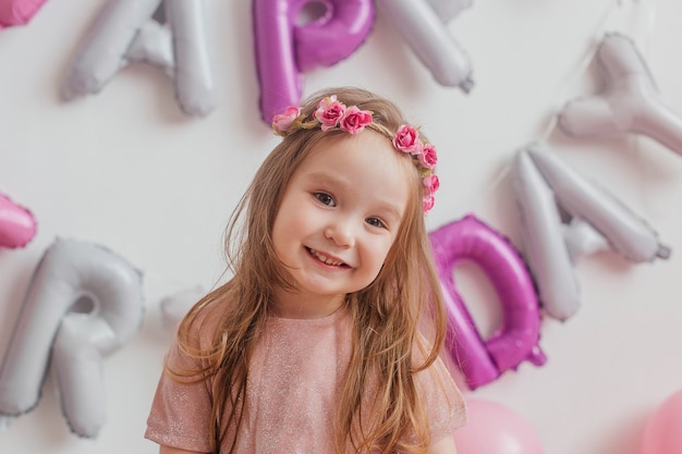 Children's birthday. Portrait of a cute little girl in a pink dress posing in front of the camera.