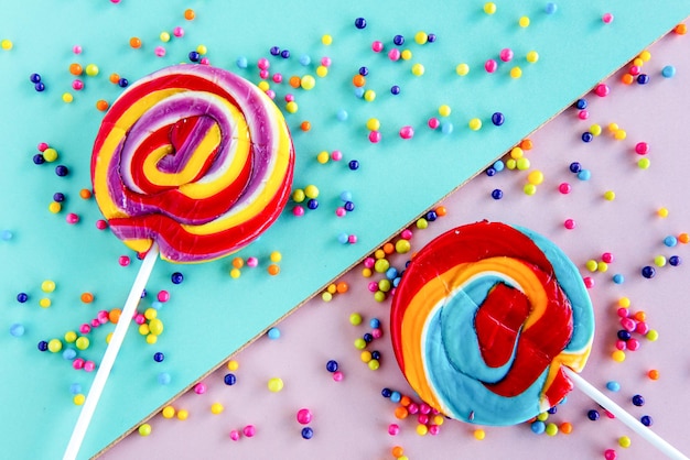 Children's candy colored lollipops and candies on green and pink background