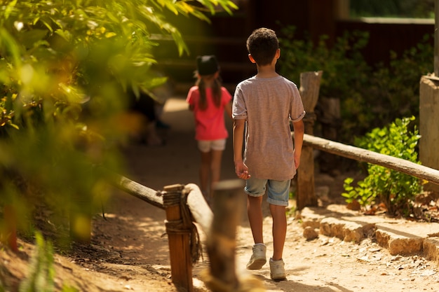 Children's Day. Little boy and girl running in the park. Back view