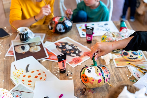 Photo children's drawing class children painting pumpkins with their parents