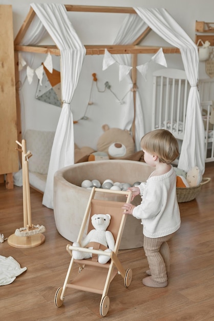 Children's educational wooden toys Nursery decor Scandinavian style playroom Wooden stroller Baby boy with wooden cart