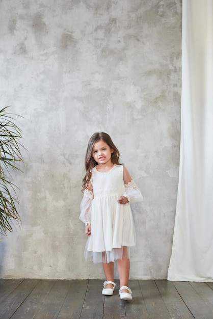 Children's fashion. Little stylish girl in white dress.