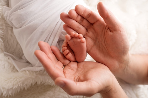 Children's feet in hold hands of mother and father. Mother, father and Child. Happy Family people concept. High quality photo