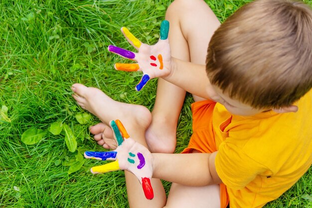 Children's hands in the colors of summer a smile on the boy's palm