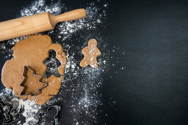 Children's hands make New Year's gingerbread cookies on a wooden table. Making cookies with a cookie cutter. New Year and Christmas concept.