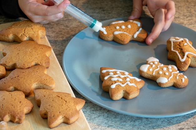 Children's hands make New Year's gingerbread cookies on a wooden table. Making cookies with a cookie cutter. New Year and Christmas concept.