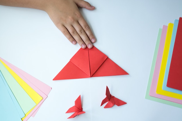 Photo children's hands do origami a butterfly.