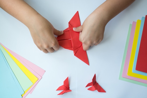 Children's hands do origami a butterfly. 