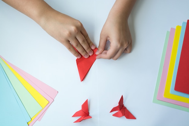 Children's hands do origami a butterfly. 