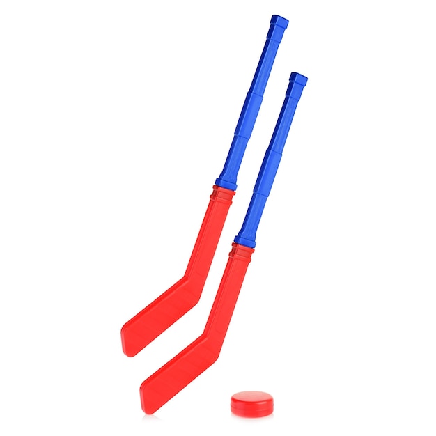 Children's hockey stick and puck for playing hockey Two blue and red hockey sticks isolated on a white background