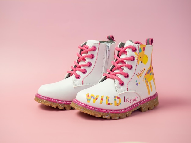 Children's leather shoes on a pink background