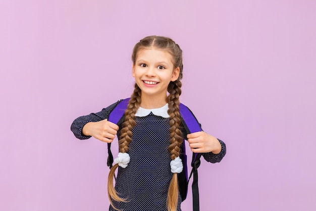 Children's primary education a little girl in a school uniform with glasses and pigtails