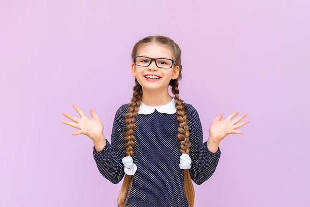 Children's primary education a little girl in a school uniform with glasses and pigtails