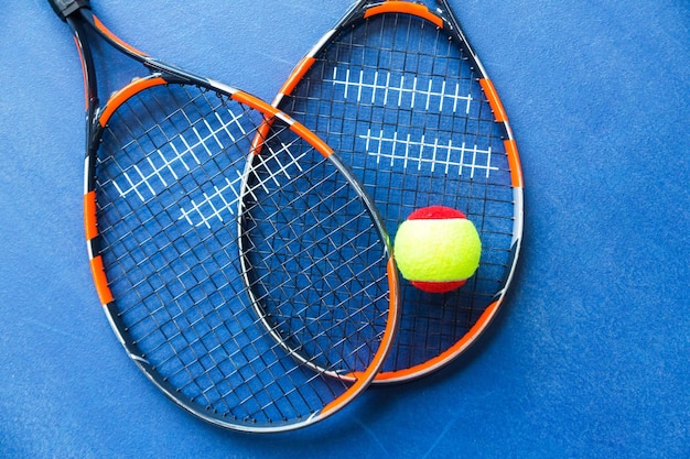 Children's Tennis ball and Tennis Rackets on blue background Horizontal photo