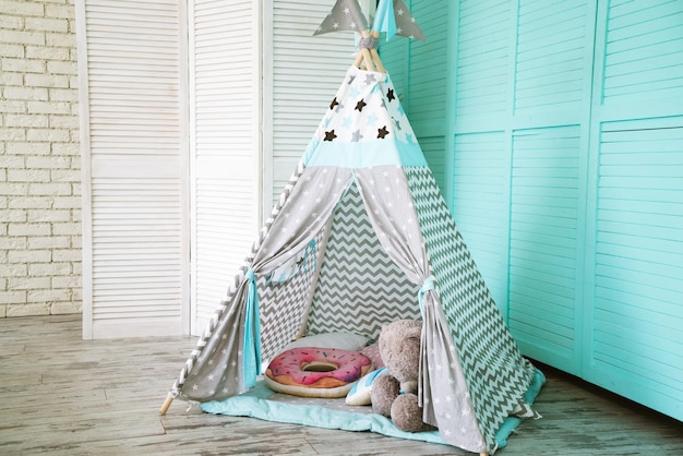 Children's tent for games in the house with a teddy bear