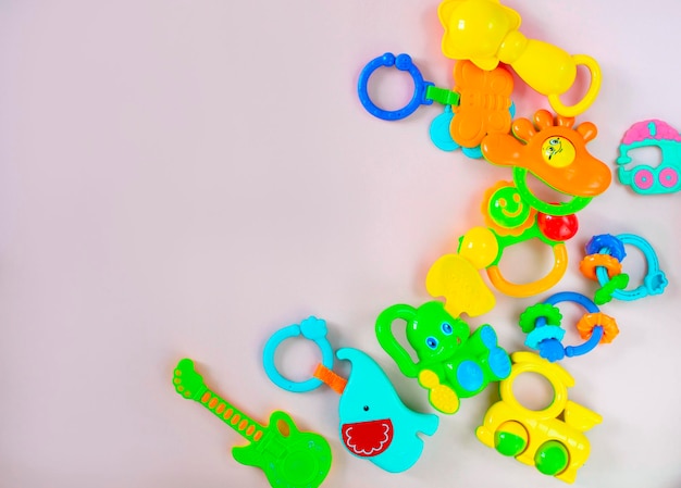 Children's toys rattles on a pink background Top view flat position The concept of child development Place for text