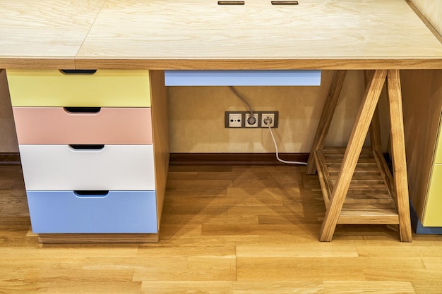 Children sawhorse desk of plywood and solid oak with cabinet and multicolored facades of drawers