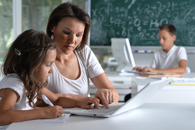 Children at school in the classroom with teacher