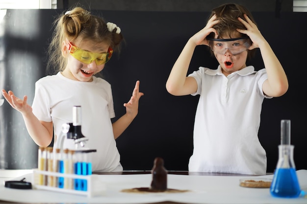 Children scientists Schoolchildren in the laboratory conduct experiments Boy and girl experiments with a microscope