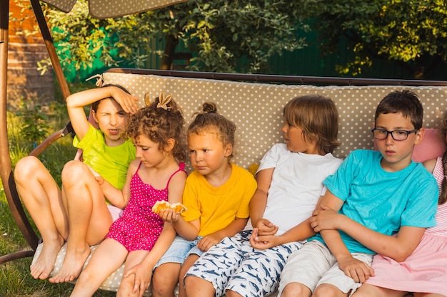 Children sitting on large swing in backyard