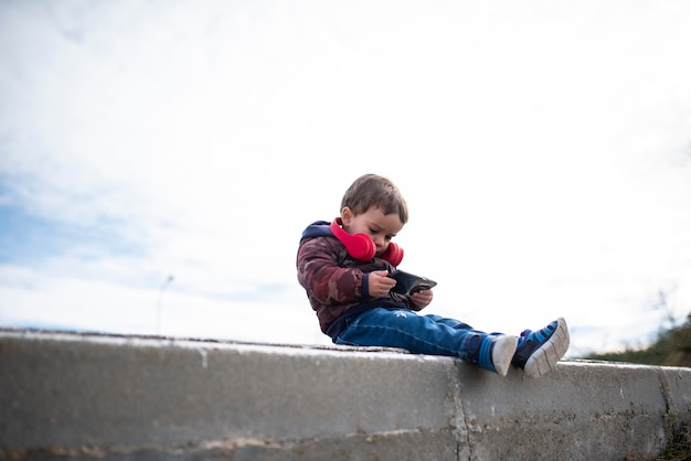 Children surfing the internet outdoors on a mobile phone