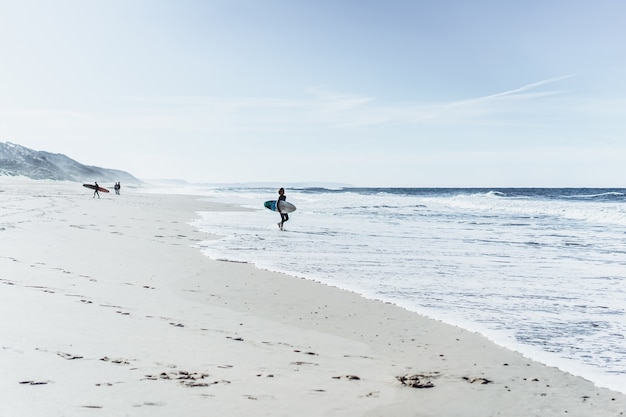 children on surfing. Nazare, Portugal. Children and teenagers in wetsuits surf boards.