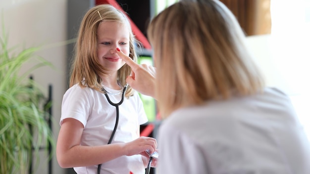 Children visit to doctor girl with stethoscope communicates with pediatrician doctor talking to