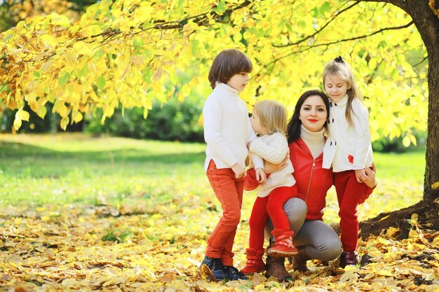 Children for a walk in the autumn park. Leaf fall in the park. Family. Fall. Happiness.