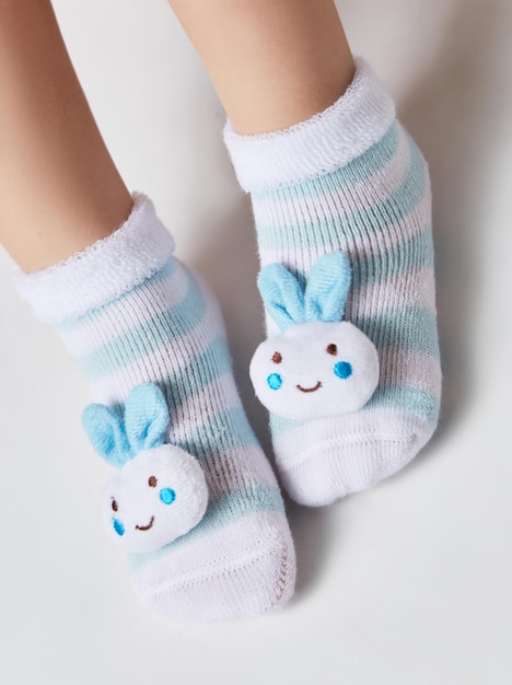 Children wearing pair of socks Top view to kids foots in mismatched socks sitting on white backgro