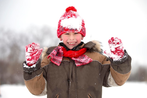 Children in winter. The happy boy plays in the snow.