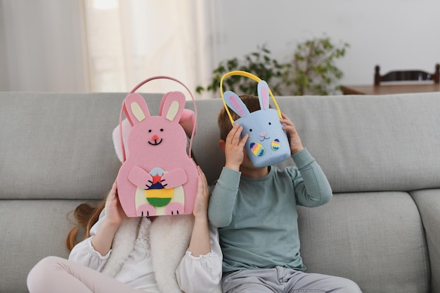 Children with bunny ears and basket for chocolate eggs Easter