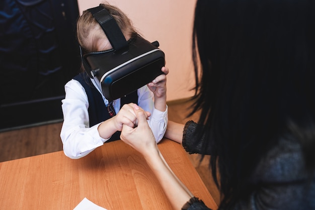 Children with virtual reality glasses are in the school office. Modern teaching methods