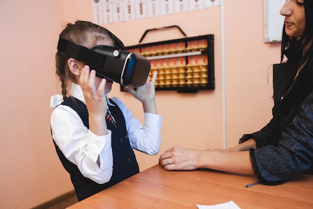 Children with virtual reality glasses are in the school office. Modern teaching methods